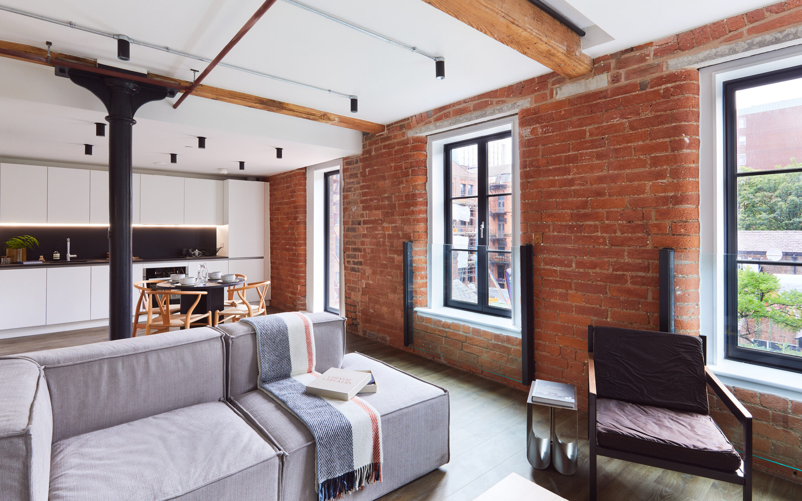 Industrial feel apartment with raw brickwork but modern clean kitchen and dining space.