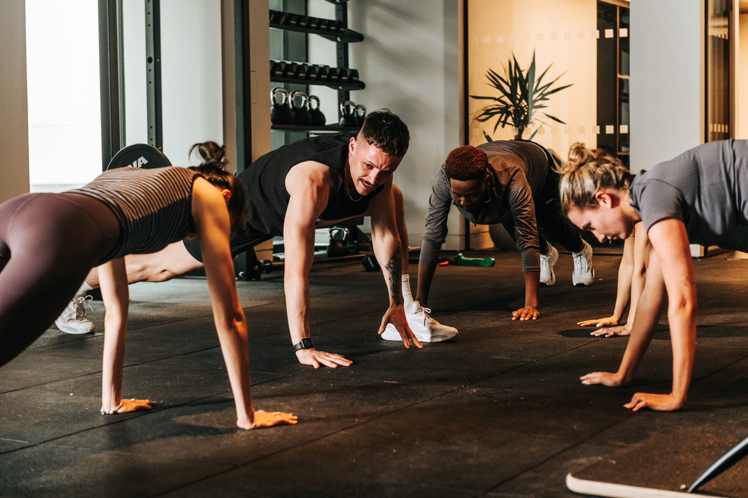 A personal trainer instructs clients inside of the Kampus Gym