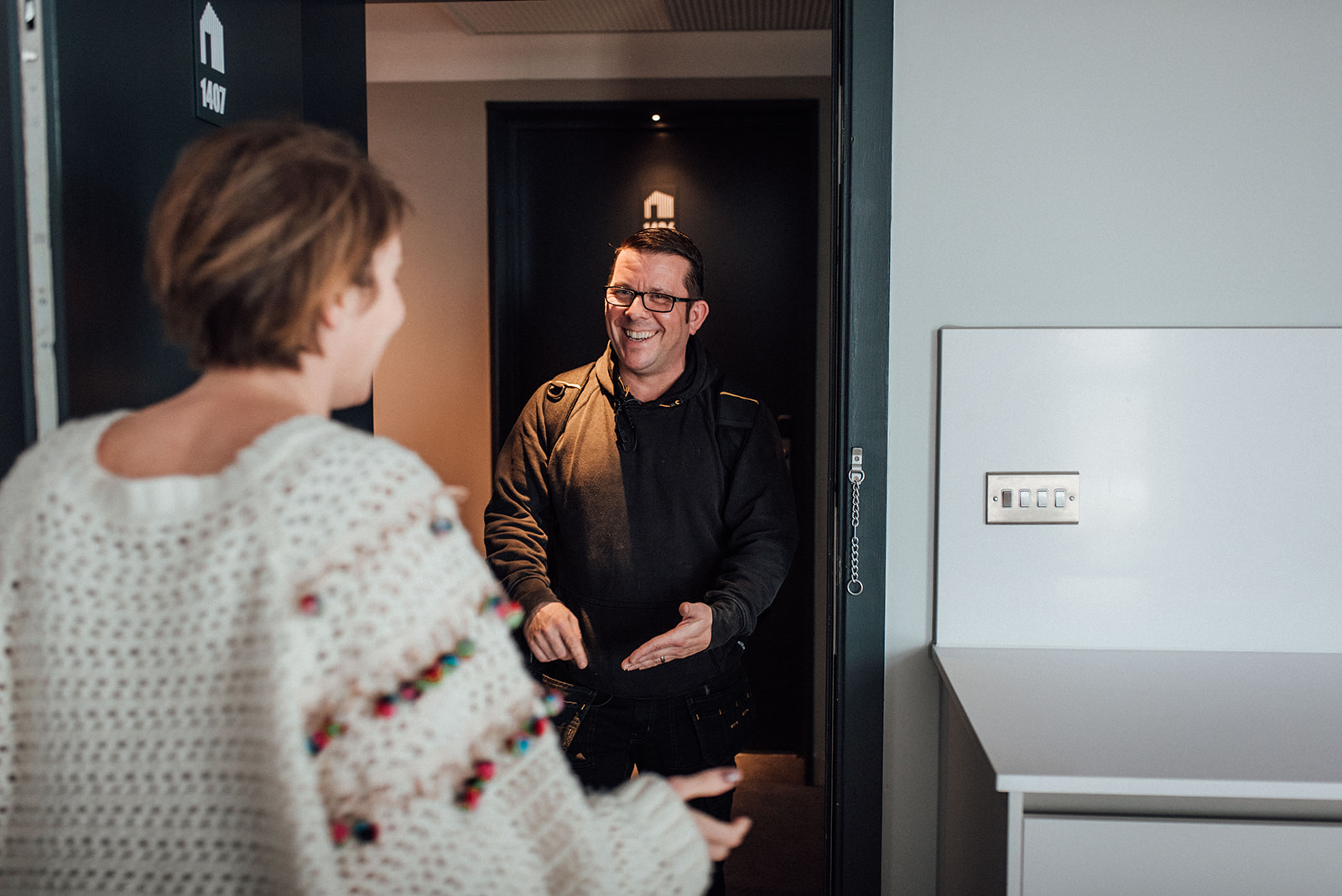 A resident happily greets an engineer as Kampus staff arrives to service apartment utilities.