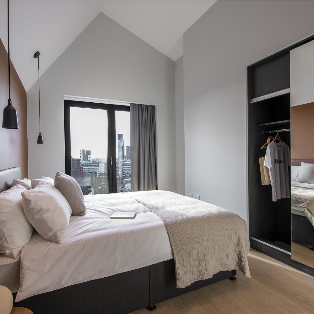 Bedroom with built in mirrored wardrobe and boutique hanging light features.