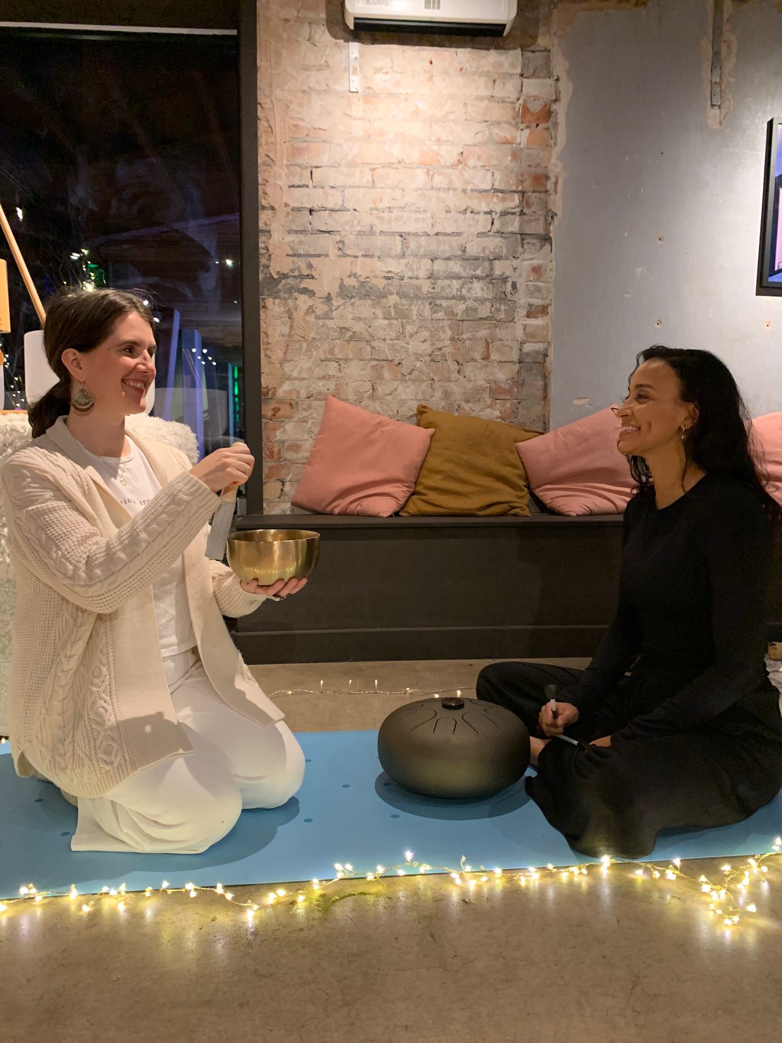 Two women perform a sound bath session